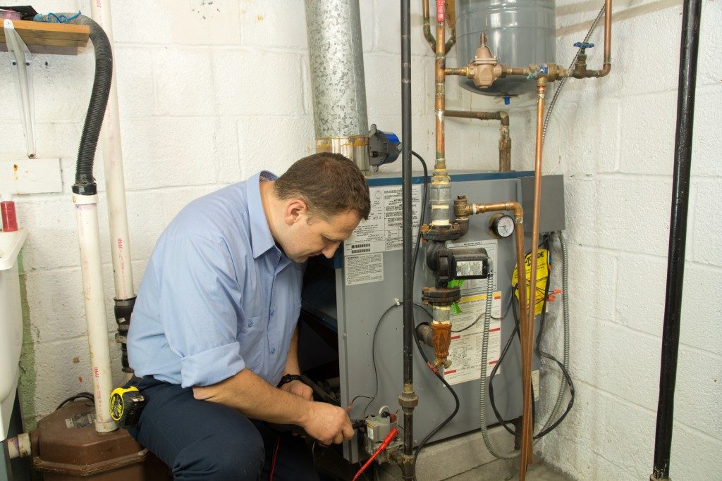 a plumber checking the gas furnace