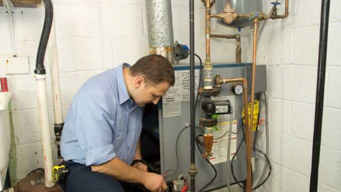 a plumber checking the gas furnace