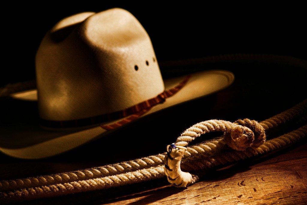 American West rodeo cowboy lasso rope and white straw hat
