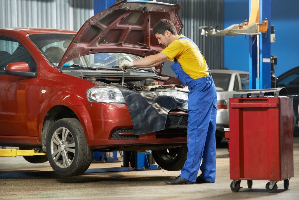 young mechanic doing car maintenance