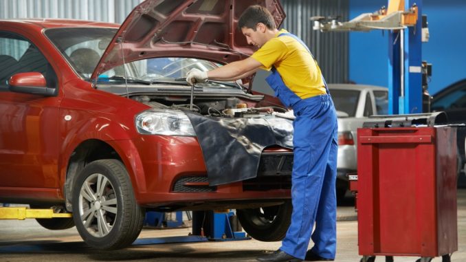 young mechanic doing car maintenance