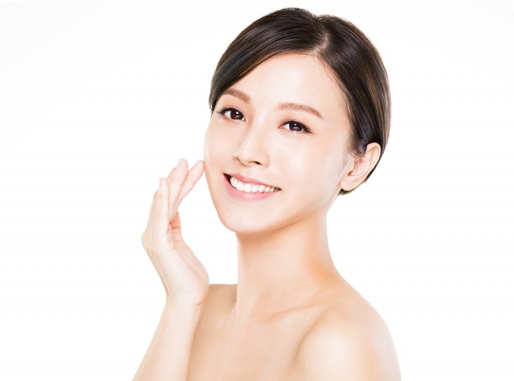 Asian woman applying cream