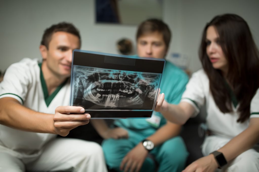 Dentist explaining to assistant the progression of tooth loss