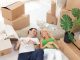 Young smiling couple relaxing in the middle of cardboard boxes in new home