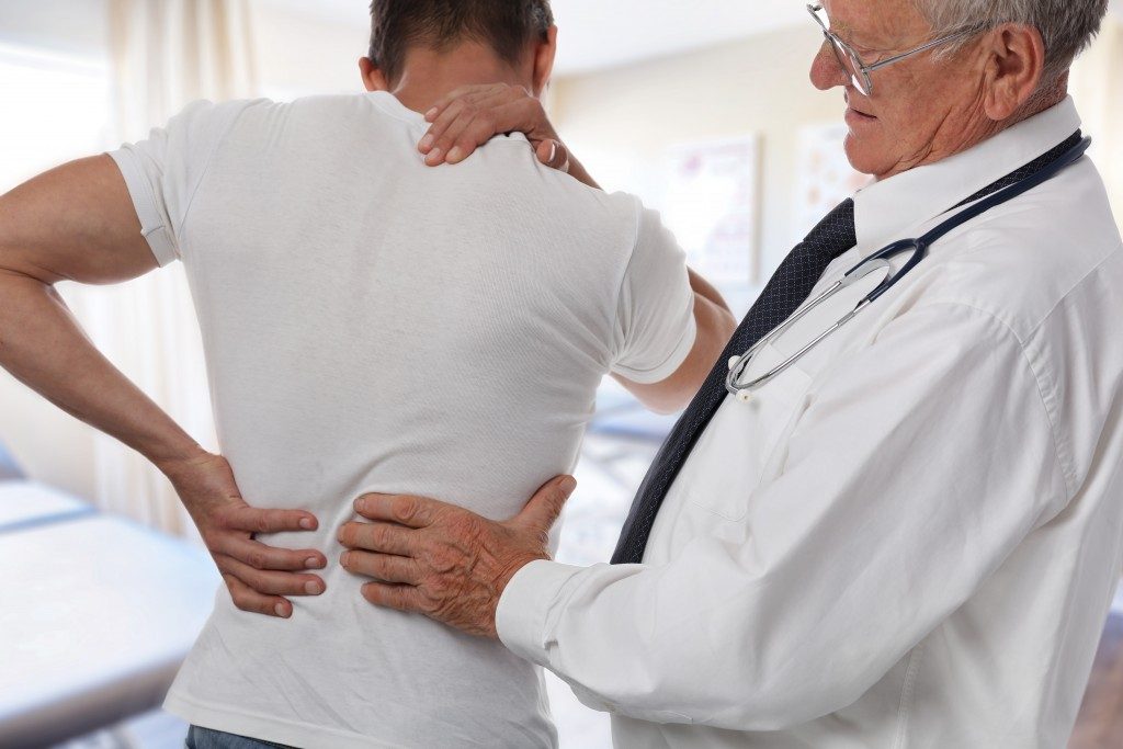doctor diagnosing man's back