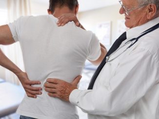 doctor diagnosing man's back