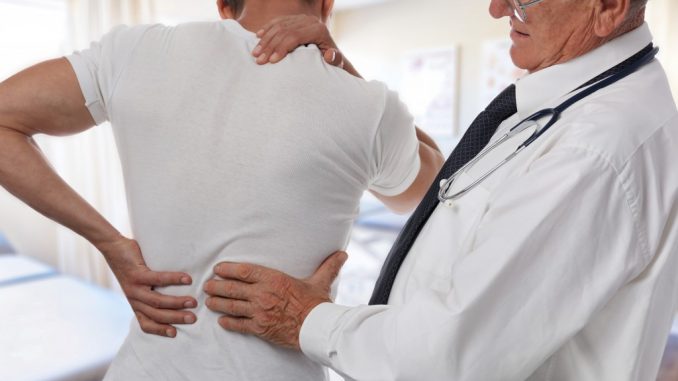 doctor diagnosing man's back