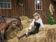 Cowgirl sitting on a pile of hay
