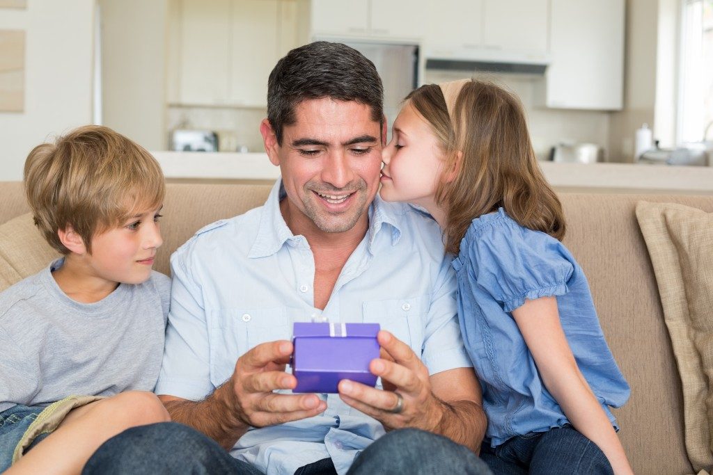 Daughter kissing father after giving the gift