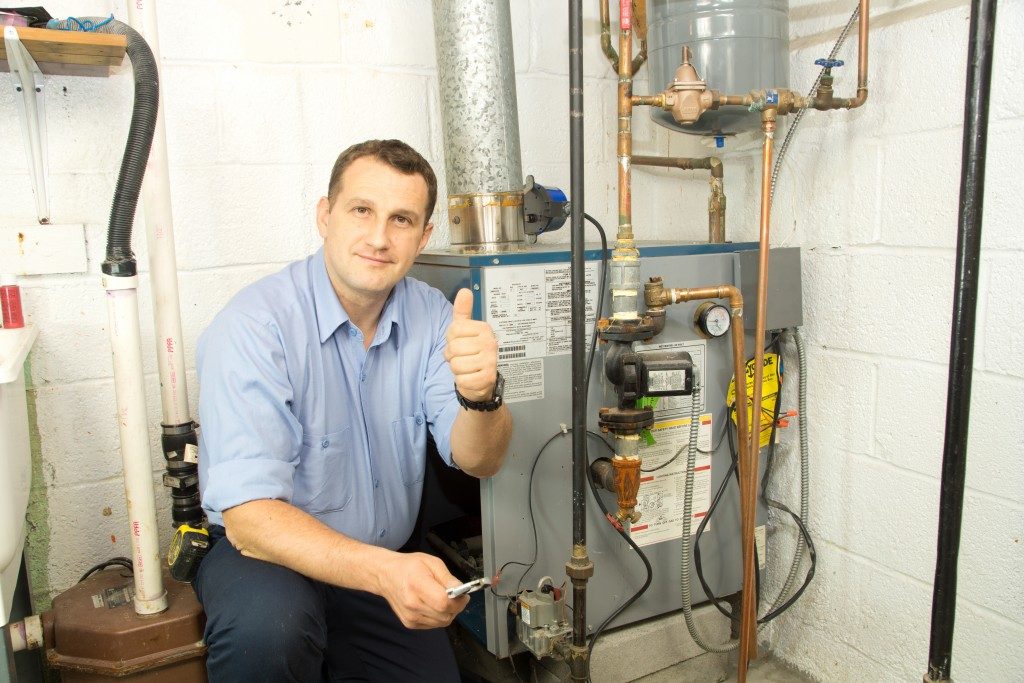 Plumber posing beside a gas furnace