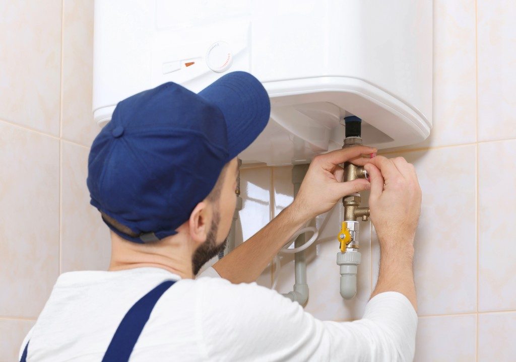 man fixing water heater