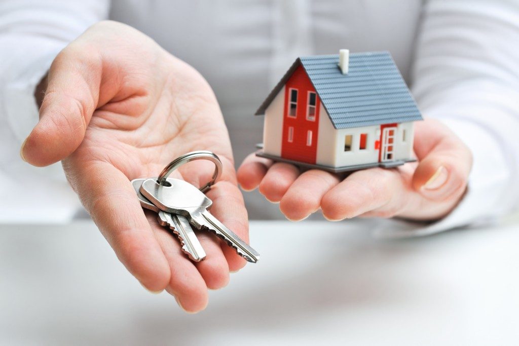 real estate agent with house model and keys
