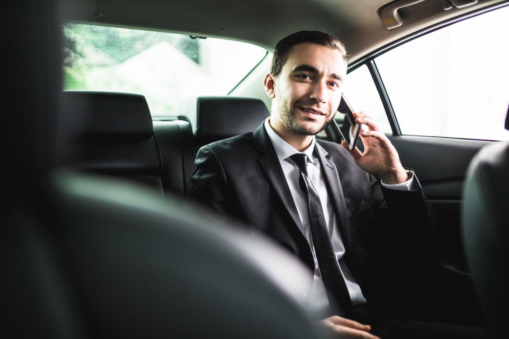 man talking to someone from the backseat