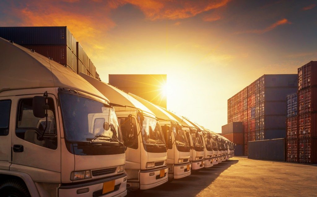 Row of cargo trucks, sunset background