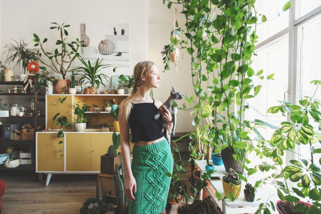 girl standing surrounded by plants