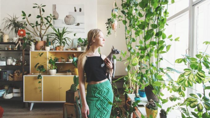 girl standing surrounded by plants