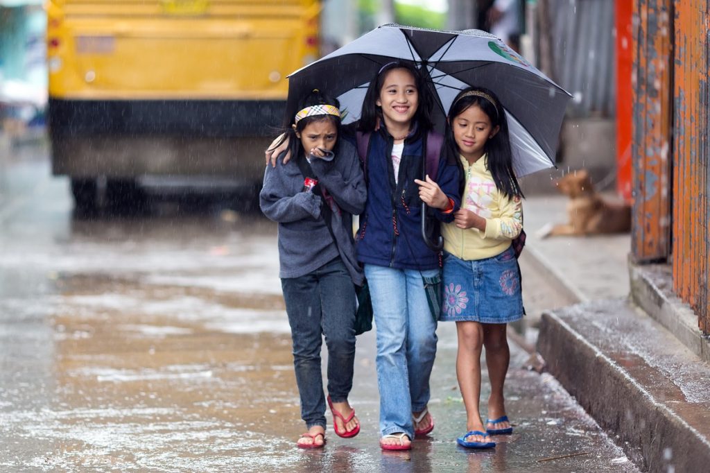 kids sharing an umbrella