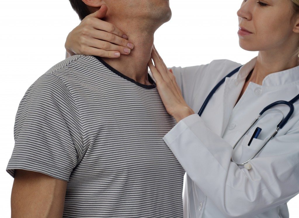 doctor massaging patient's throat