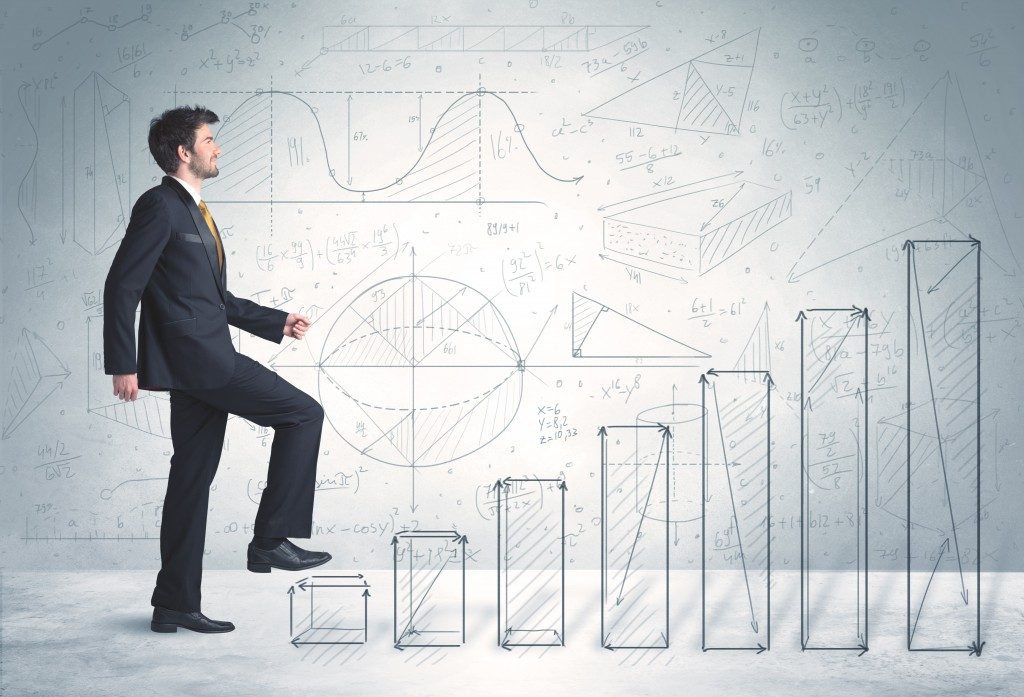 business man climbing bar chart ladder