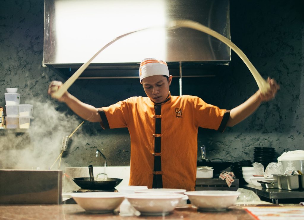 asian chef making noodles