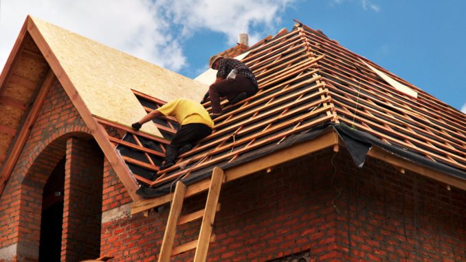 two men fixing roof