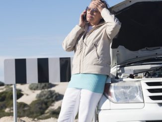 woman on the phone on the side of ride broken down car
