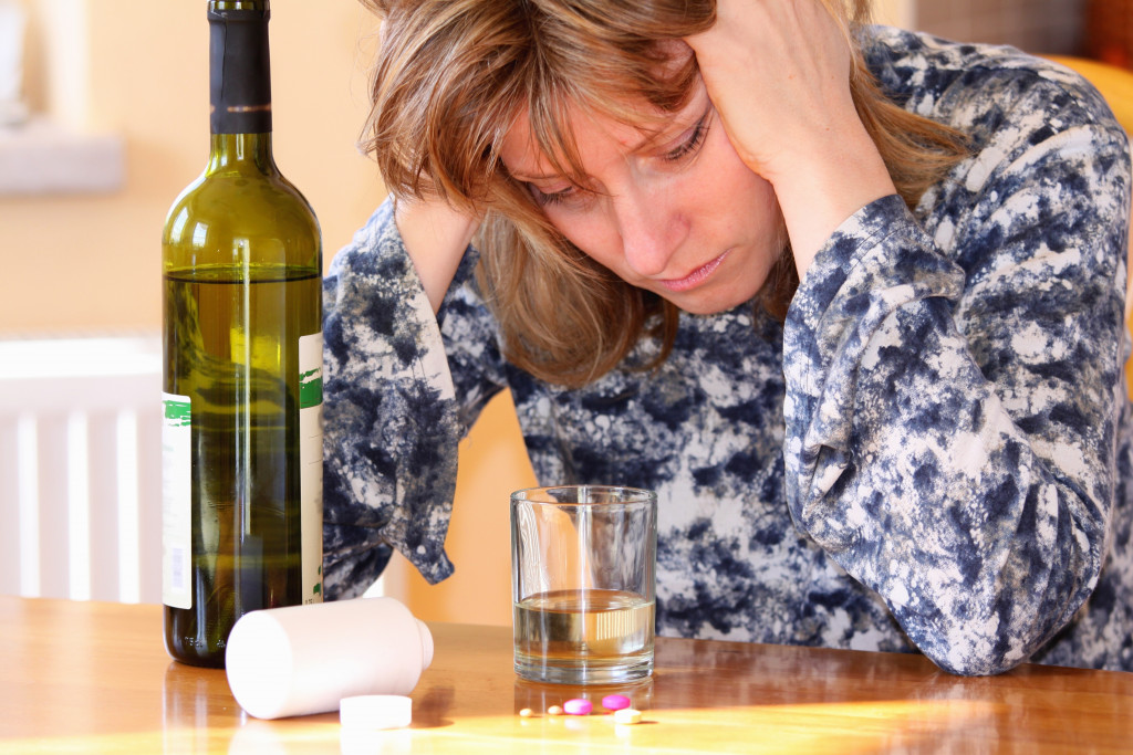 woman drowning herself on a bottle of wine