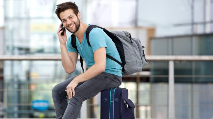 man sitting on his suitcase