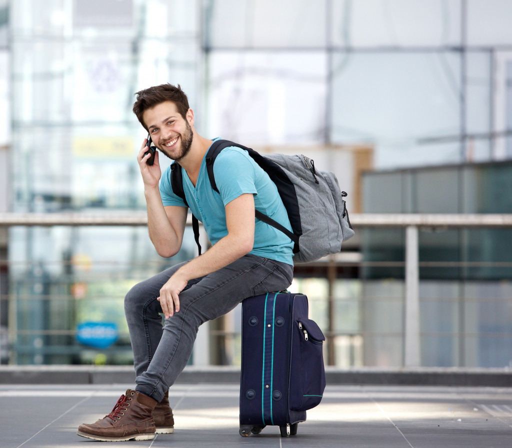 man sitting on his suitcase