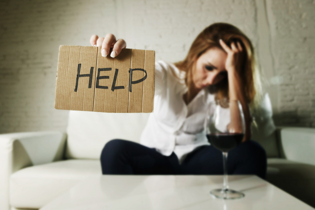 woman holding a help sigh while clutching her hair